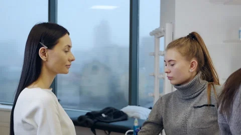 Apprentice make-up artist or applies foundation, powder, brush to the model's Video stock 166921346