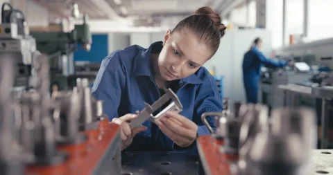 Apprentice measuring metal bolt with caliper in workshop Video stock 254680519