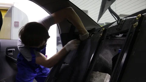 Apprentice Mechanic Working On Car removes the seat belt. Stock Footage 98856971