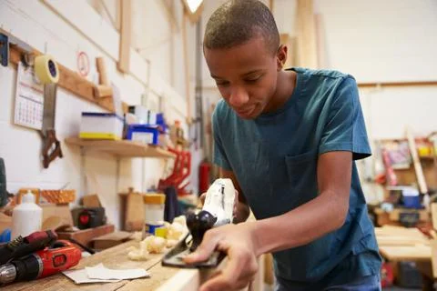 Apprentice Planing Wood In Carpentry Workshop Stock Photos