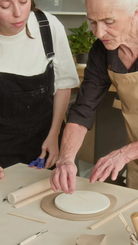 Apprentice Shaping Clay Using Stencil in Workshop Stock Footage 331810792