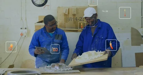 Apprentice tapping tablet while lead tilting model, numeric overlays guiding Video stock 334311706