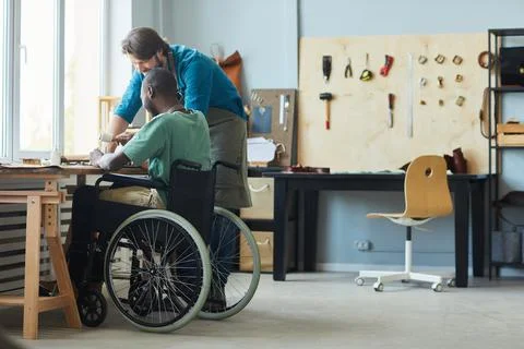 Apprentice using Wheelchair in Leathermaking Workshop Foto stock