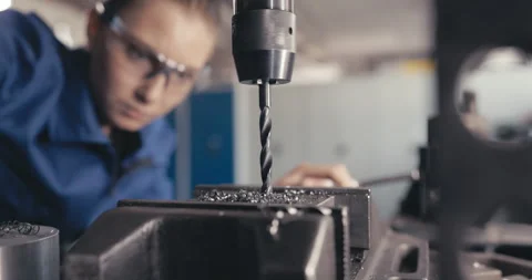 Apprentice watching drill drilling metal in workshop Video stock 254676768