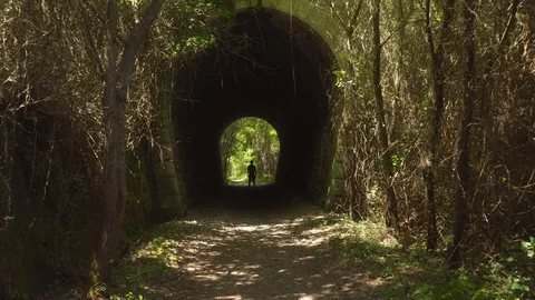 Approach of camera to man standing still in a tunnel Stock Footage 112294217