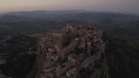 Approaching an ancient old town hanging on a cliff with a medieval castle Stock Footage 121207976
