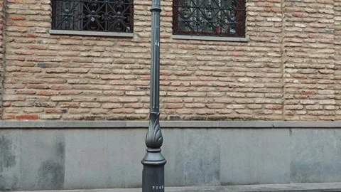 Approaching brick facade with ornate windows and lamppost Vidéo 310299719