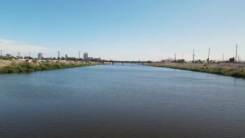 Approaching A Bridge Spanning A River In An Urban Landscape Vídeo Stock 209681167