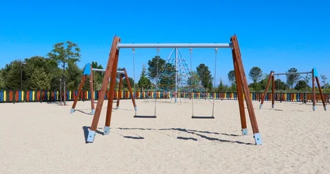 Approaching double empty swings in playground Stock Footage 93792522