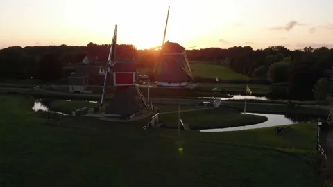 Approaching, a drone shot on windmills standing in a field in a Dutch village. Stock Footage 174689059