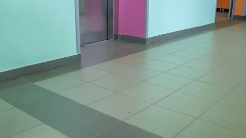 Approaching an elevator and having her leg in a plaster Stock Footage 78540528