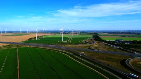 Approaching an Extensive Wind Farm and a Highway Interchange. Video stock 296713191