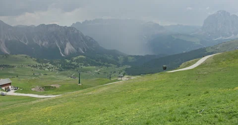 Approaching rainstorm over the green valley in dolomites Stockbeeldmateriaal 340780280