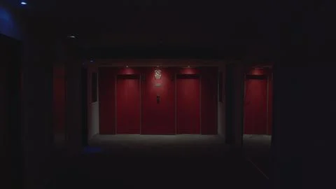 Approaching red elevator doors in dark corridor 스톡 사진
