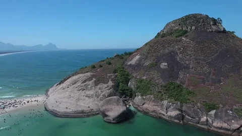 Approaching the rock and a flight over bathers on the beach Stock Footage 81137901