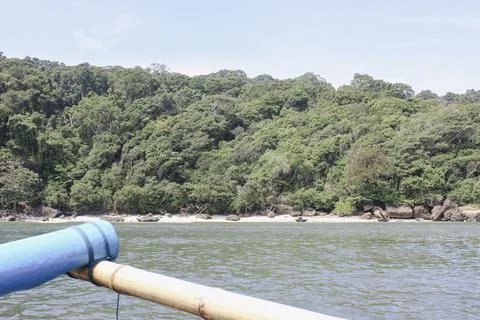 Approaching a secluded tropical beach from a small boat on calm water Stock Photos