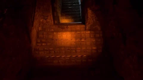 Approaching staircase in dark underground passage with caution tape Stock Footage 314398349
