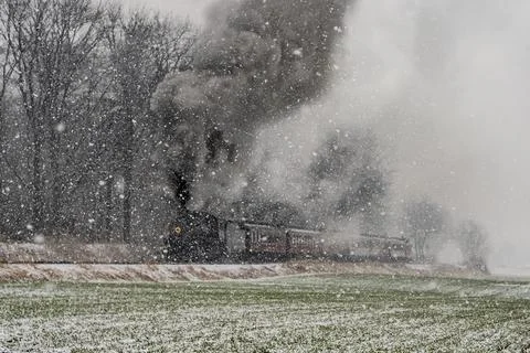 Approaching Stem Passenger Train, in a Snow Storm, Blowing Black and White Smoke Stock Photos