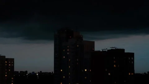 Approaching storm clouds over city buildings at night Vídeo Stock 311863189