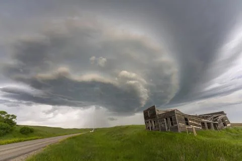 Approaching supercell storm cloud over abandoned wooden building and count... Fotos de archivo