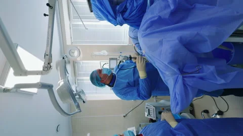 Approaching the surgeon and assistant standing near the operational table. Stock Footage 254301021