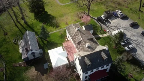 An approaching top-view aerial shot of a white house surrounded by grass Vídeo Stock 182484292