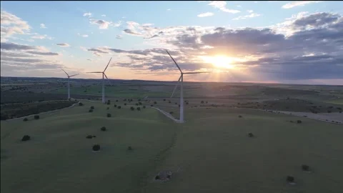 Approaching windmills spinning with the sun in front of them Stock Footage 274192850