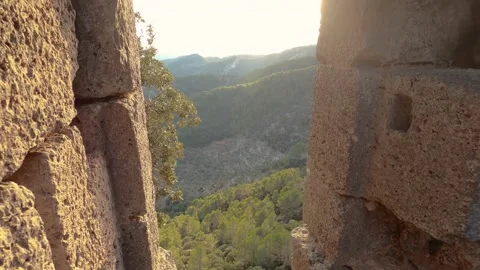 Approaching the window of a stone wall from where you can see a mountain Stock Footage 261744366
