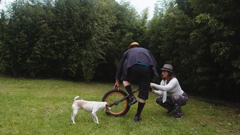 Appropriate use of a monocycle by a very dapper couple even the dog gives up in Stock Footage 113937303