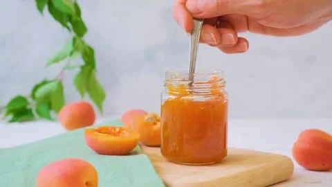 Apricot jam in a jar. It's fruit preparation season. Stock Footage 285220346