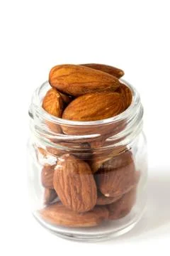 Apricot kernels in opened small glass jar isolated on white background Foto stock