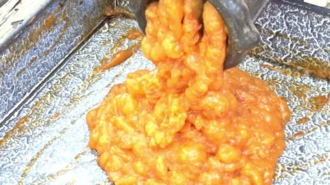Apricot pulp exiting a hand grinder during homemade jam preparation Stock Footage 338000033