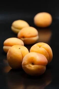 Apricots on black reflective background Stock Photos