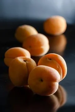 Apricots on black reflective background Stock Photos