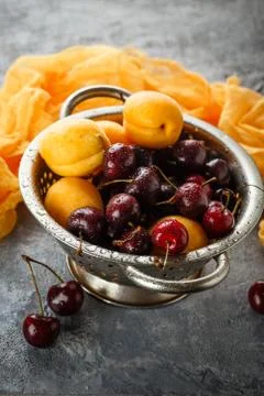 Apricots, sweets cherries in colander Stock Photos