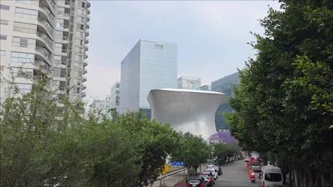 April 11, 2026, view of the Soumaya Museum and Plaza Carso among jacaranda .. Stock Footage 334872882