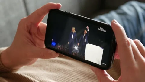 APRIL 25, 2022: Emmanuel Macron gives Victory Speech, Man on the Couch Watching Stock Footage 228612925