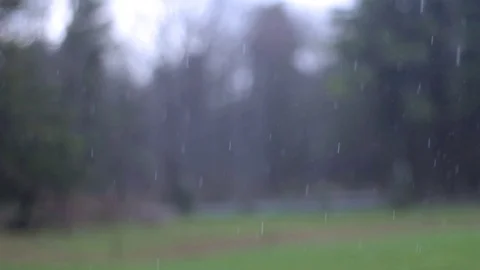 April shower raining against a front yard in the country Stock Footage 74568334