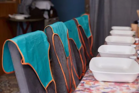 Aprons are hanging on empty chairs in front of the ebre master class Stock Photos