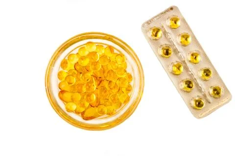 ?apsules with vitamins A and E. Yellow capsuls in glass bowl and blister with Stock Photos