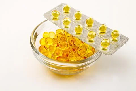 ?apsules with vitamins A and E. Yellow capsuls in glass bowl and blister with Stock Photos