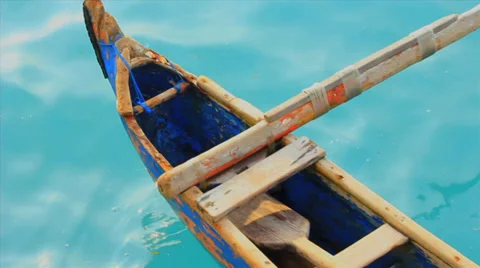 Aqua ocean in Bali floats an empty fishing canoe Stock Footage 36044505