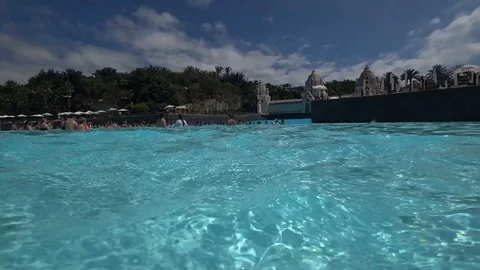 Aqua park fun people in pool with artificial wave in sunny summer day Stock Footage 116247789