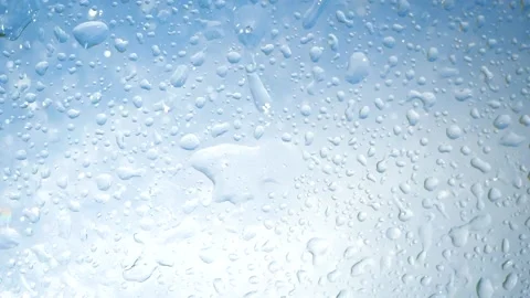 Aqua purity liquid in sun rays falls from blue sky. Beautiful stains, water Stock Footage 133636764