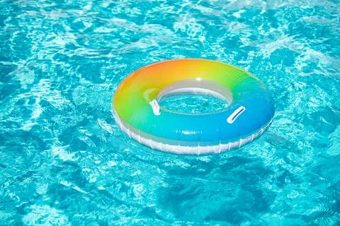 Aqua textured. Pool float, ring floating in a refreshing blue swimming pool on Stock Photos