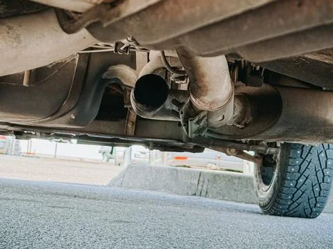Ar Exhaust System Underside Close-Up with Rust and Damage 库存照片