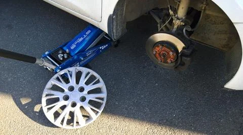 Ar raised on jack. Changing flat tire on your own. Wheel replacement. Outdoor Stock Photos