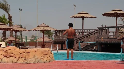 Arab boy dives into a pool Stock Footage 54074482