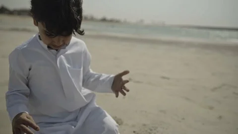 Arab boy playing with sand. Stock Footage 108256864