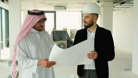Arab businessman and construction engineer discussing blueprints Stock Footage 316735262